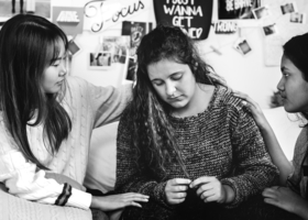 Women trying to console a woman who is socially isolated and is feeling low